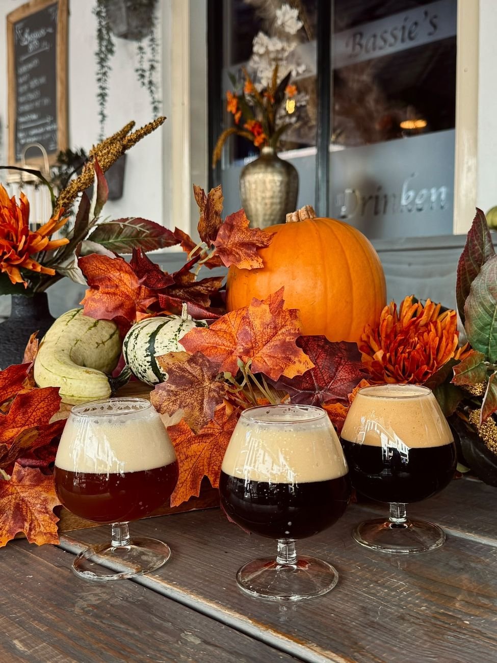 Drie glazen bokbier tussen herfstdecoratie