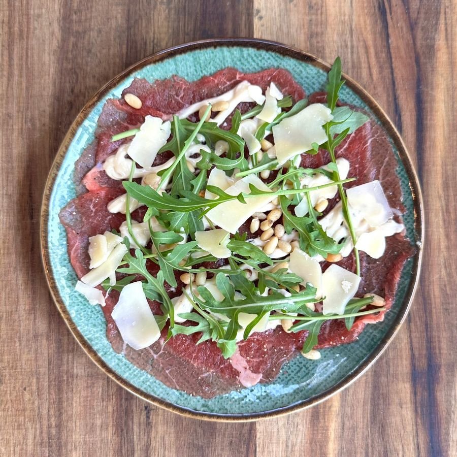 Carpaccio met rucola, Parmezaan en pijnboompitten