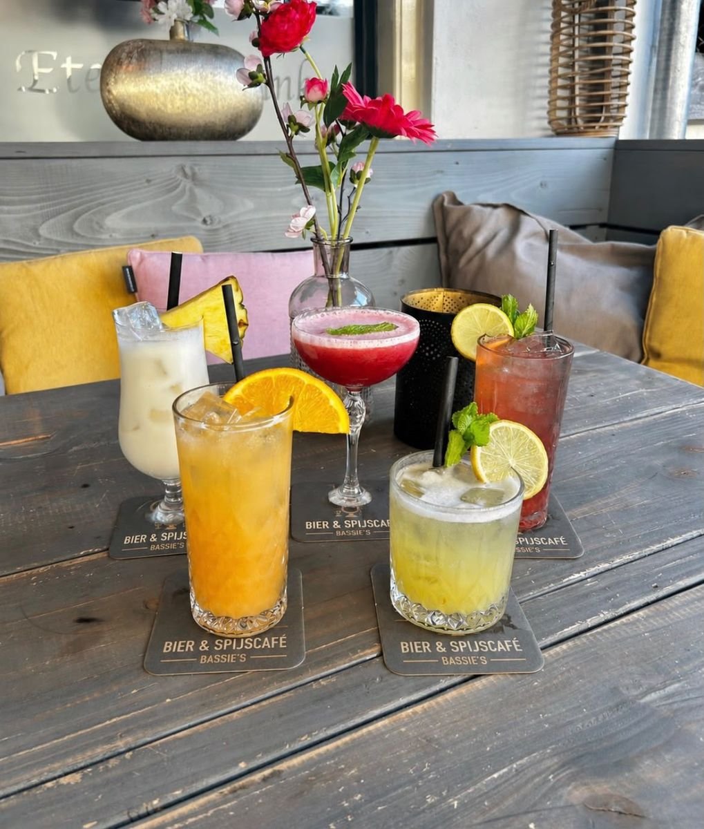 Kleurrijke cocktails en frisdrank op een tafel bij Bassie's