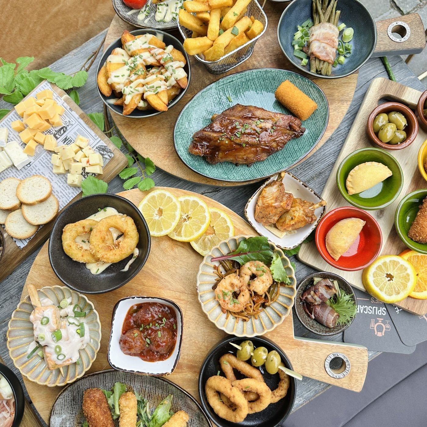 Tafel van bovenaf met tapas, nacho's, spiesjes en sinaasappel