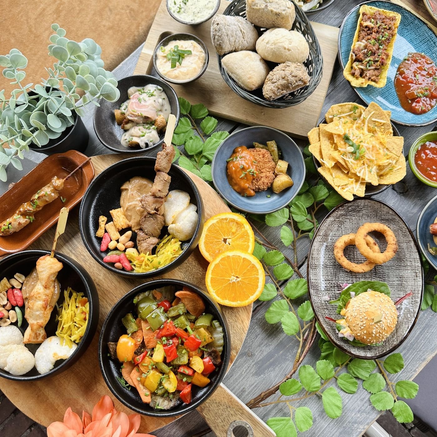 Tafel met tapas van bovenaf: biefstuk, inktvisringen, kaas en citroen
